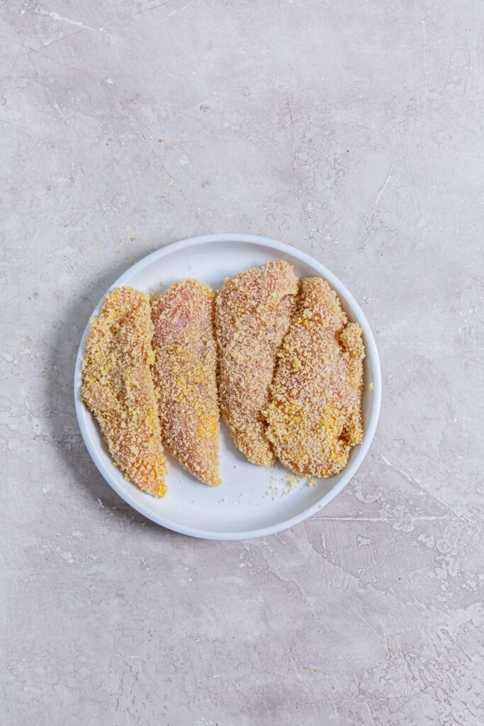 Air Fryer Katsu Chicken Sandwich Raw Breaded Chicken Strips on a White Plate