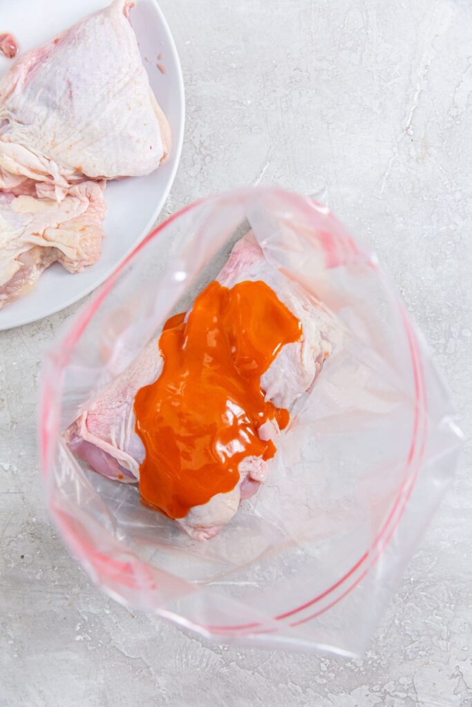 Air Fryer Buffalo Chicken Thighs ziplock bag with chicken and sauce inside