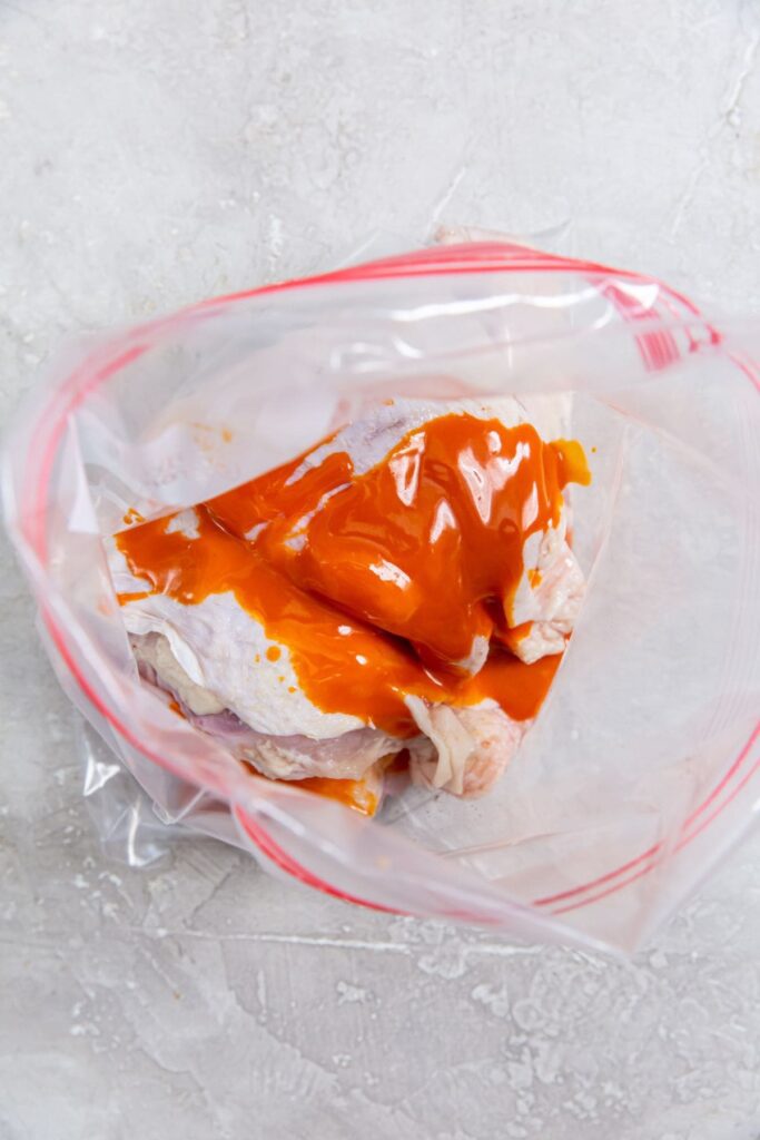 Air Fryer Buffalo Chicken Thighs ziplock bag with chicken and sauce inside