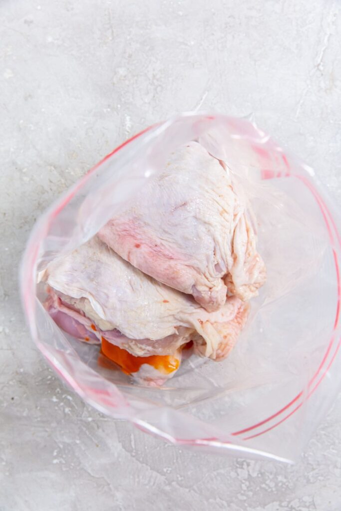 Air Fryer Buffalo Chicken Thighs ziplock bag with chicken and sauce inside