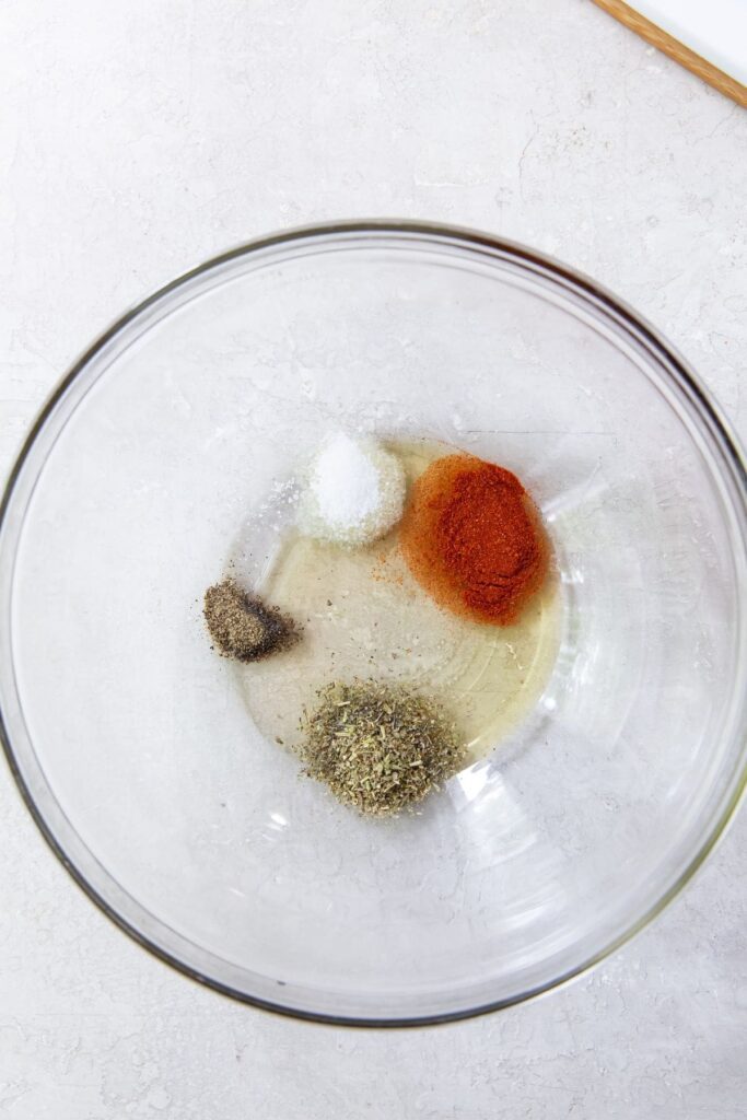 Air Fryer Chicken Breast Strips Gray background with large mixing bowl that has all the ingredients inside it