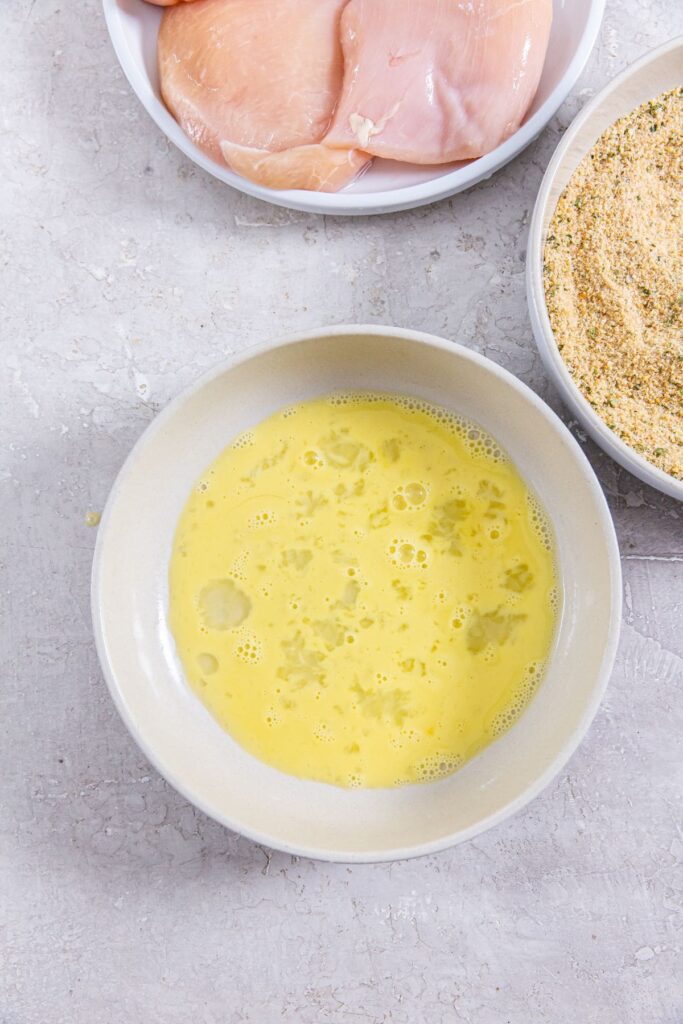 Air Fryer Chicken Cutlets three bowls egg wash, bread crumbs, and chicken cutlets