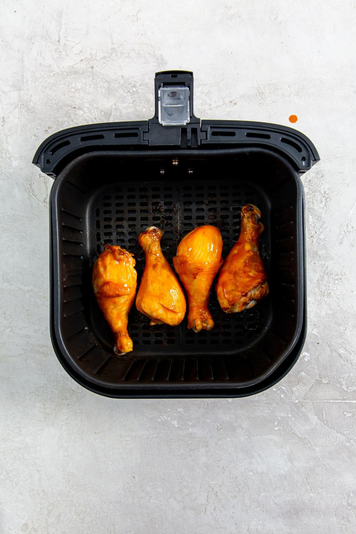 Air Fryer Buffalo Chicken Legs black air fryer basket with chicken inside
