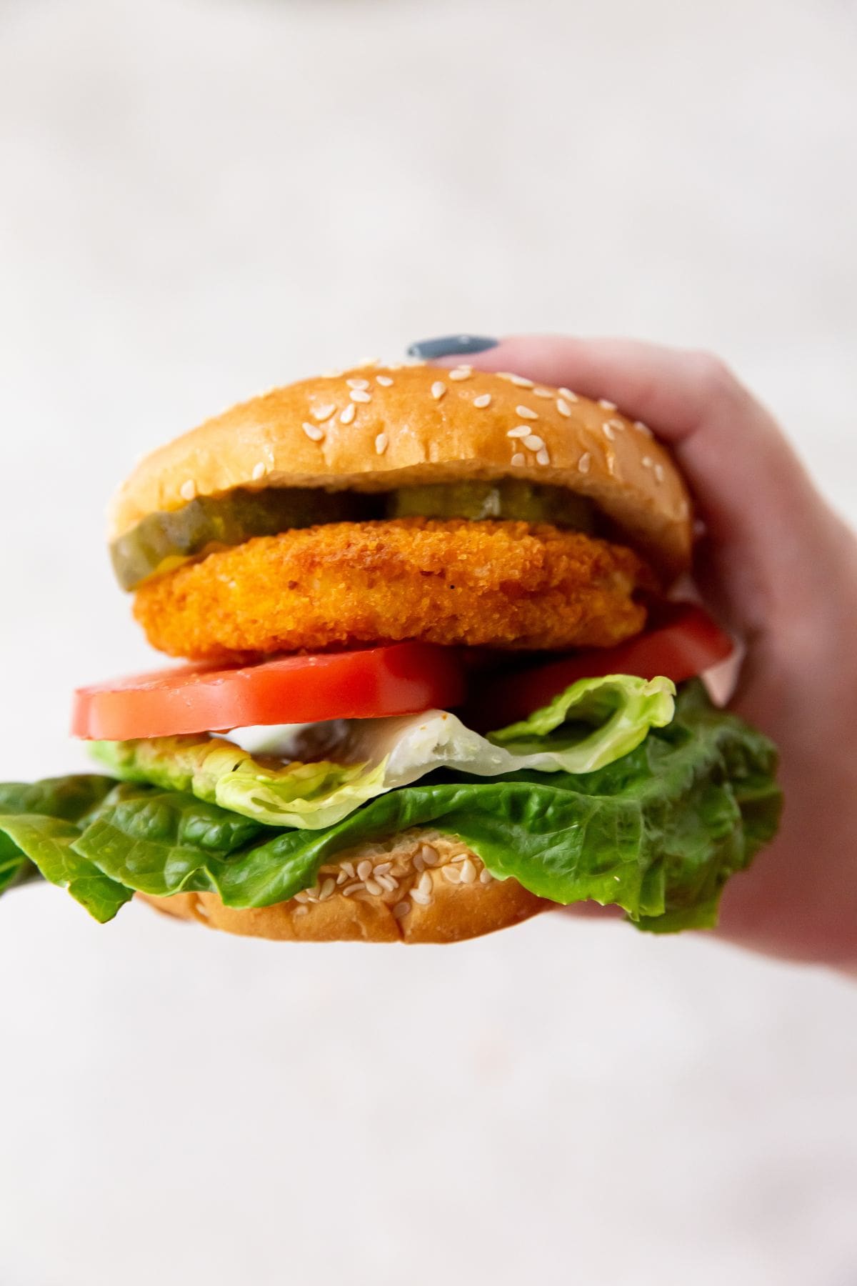 Air Fryer Chicken Patty Hamburger bun that has tomato lettuce chicken Pattie and pickles