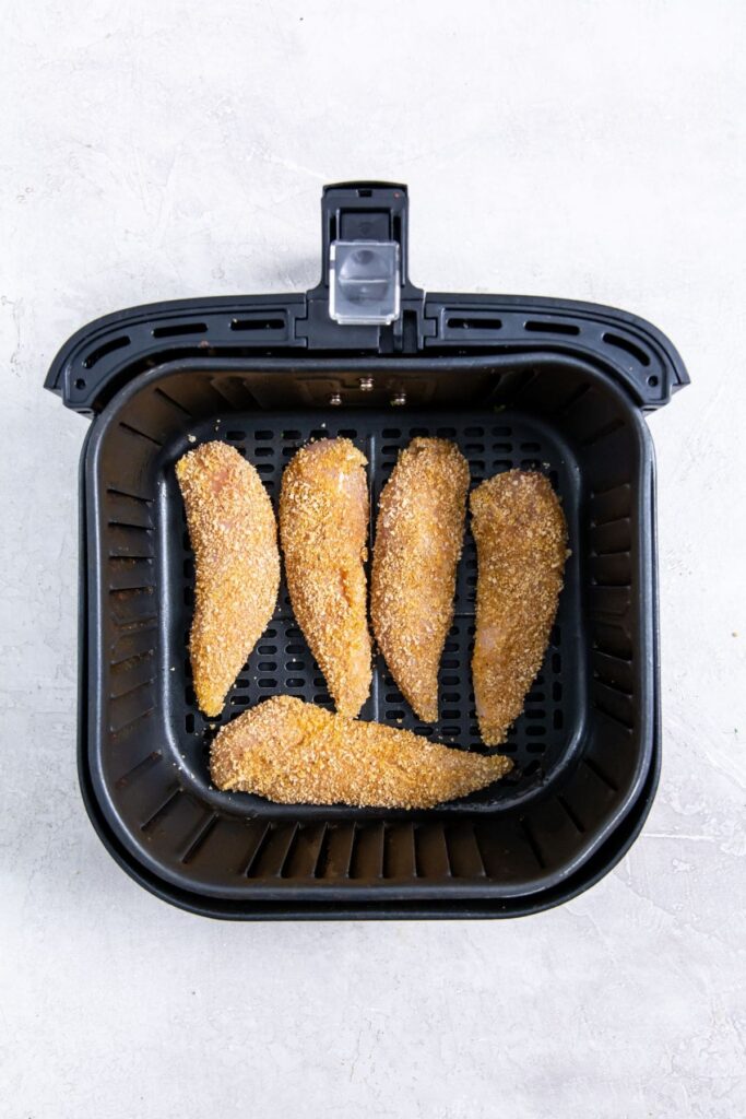 Air Fryer Shake N Bake Chicken Tenders black air fryer with raw chicken inside
