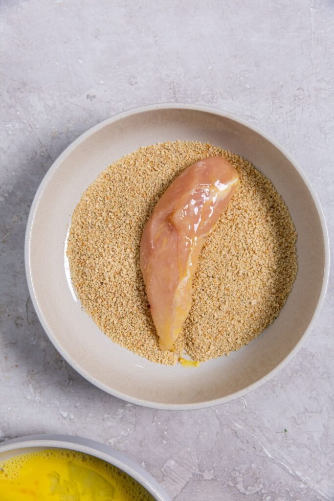 Air Fryer Shake N Bake Chicken Tenders bowl with seasoning with chicken inside