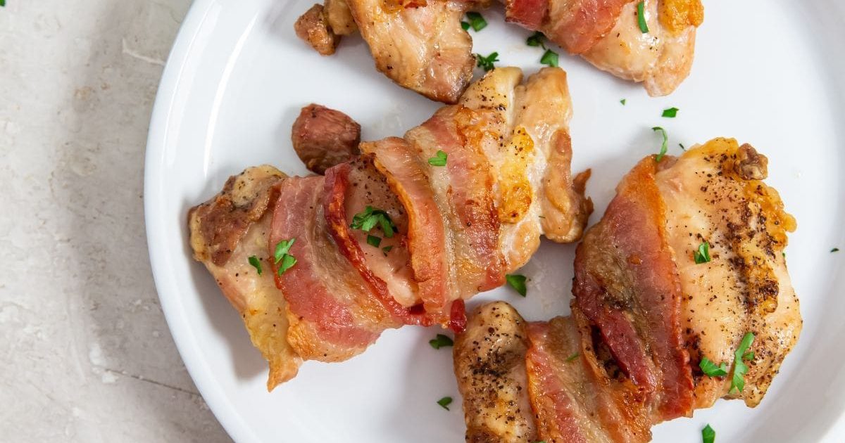 Dinner Ideas for Two Easy Air Fryer Bacon-Wrapped Chicken Thighs on a White Plate