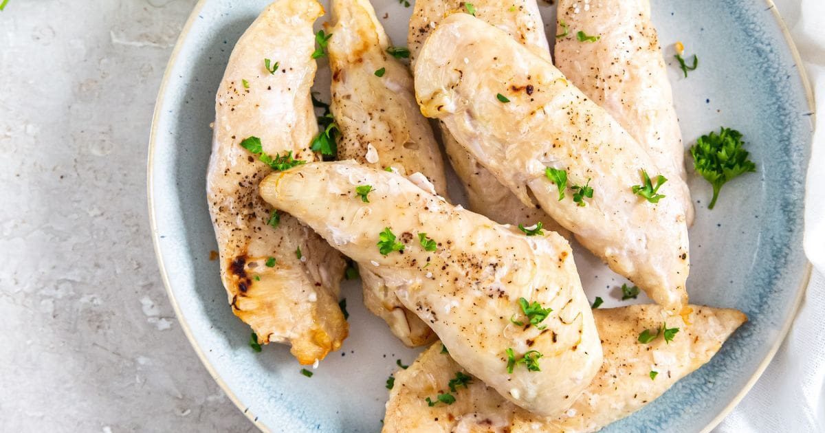 Foolproof Chicken Air Fryer Recipes a Pile of Frozen Chicken Tenders in an Air Fryer on a Light Blue Plate