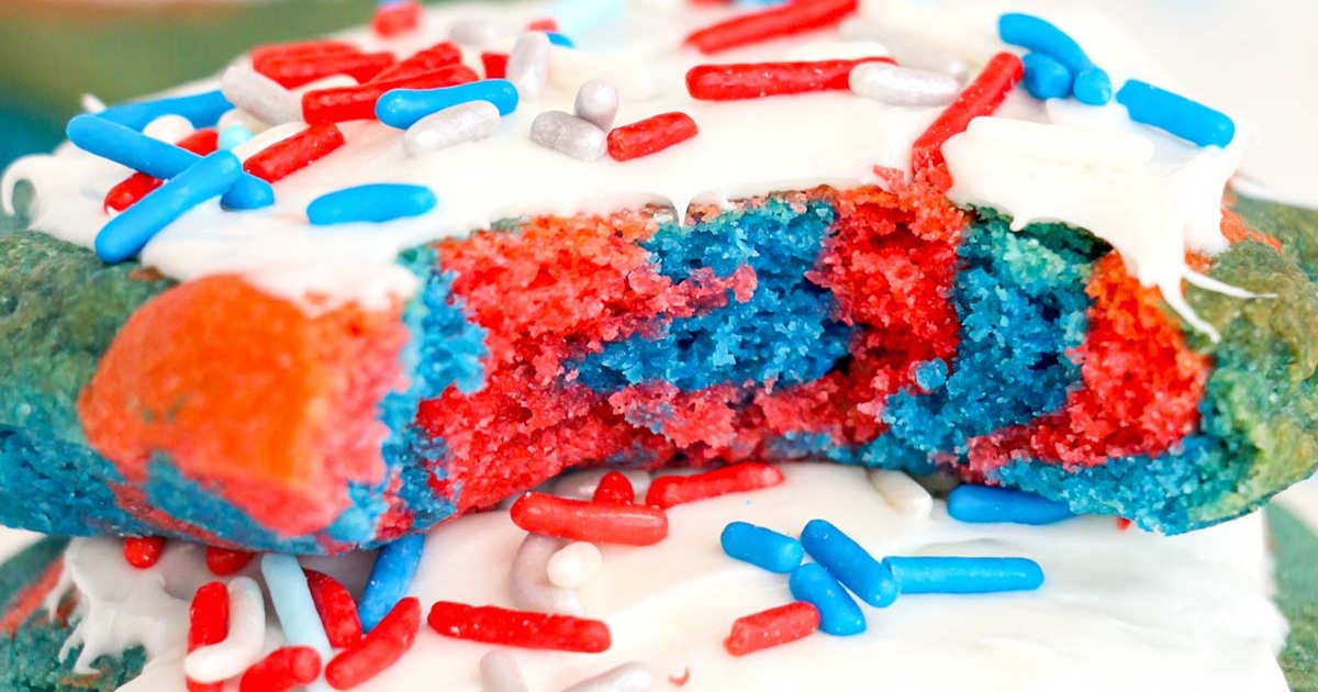 Patriotic Memorial Day Air Fryer Recipes Close Up of Red and Blue Cookies with White Frosting and Red, White and Blue Sprinkles, One Cookie Has a Bite Taken From it