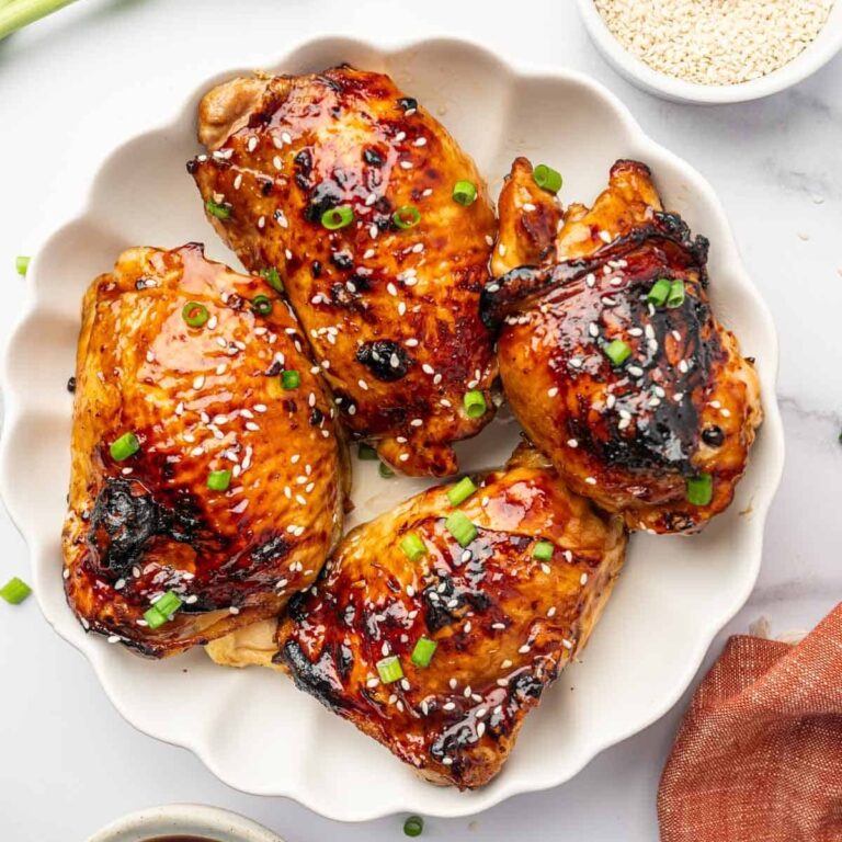 Air Fryer Bone-In Chicken Thigh Recipes a Plate of Chicken Thighs Covered in Sauce and Garnished with Diced Green Onions