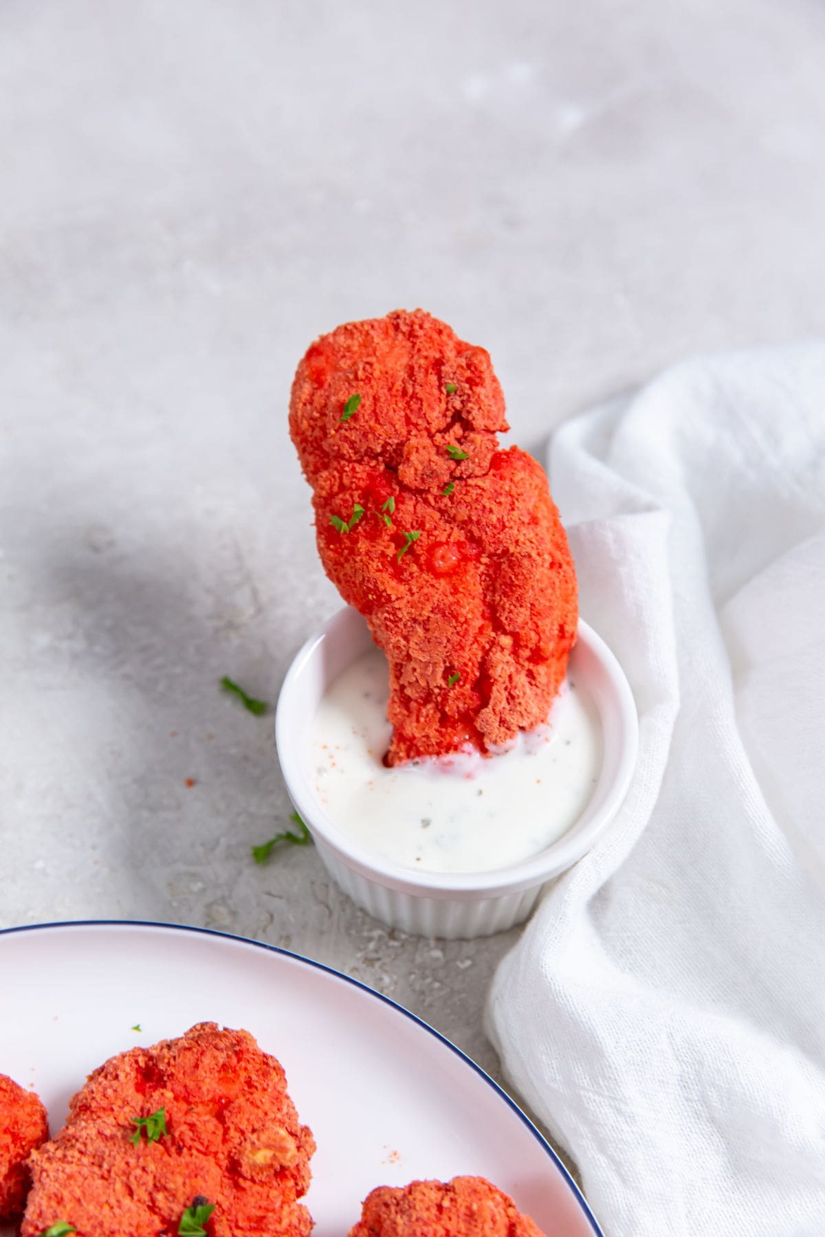 Air Fryer Flamin' Hot Cheetos Chicken Tenders chicken dunked in ranch