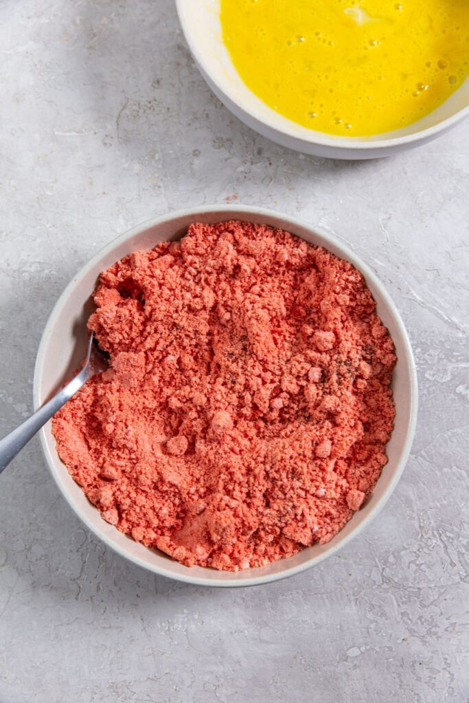 Air Fryer Flamin' Hot Cheetos Chicken Tenders Cheetos crumbs inside a bowl and an egg in another bowl