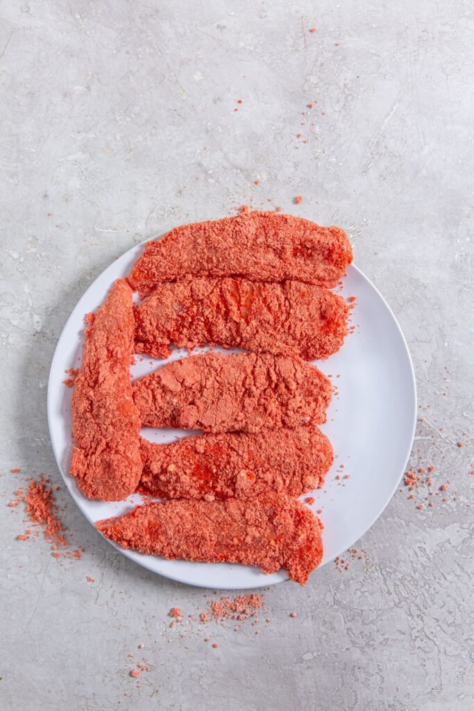 Air Fryer Flamin' Hot Cheetos Chicken Tenders plate full of chicken tenders in Cheetos crumbs