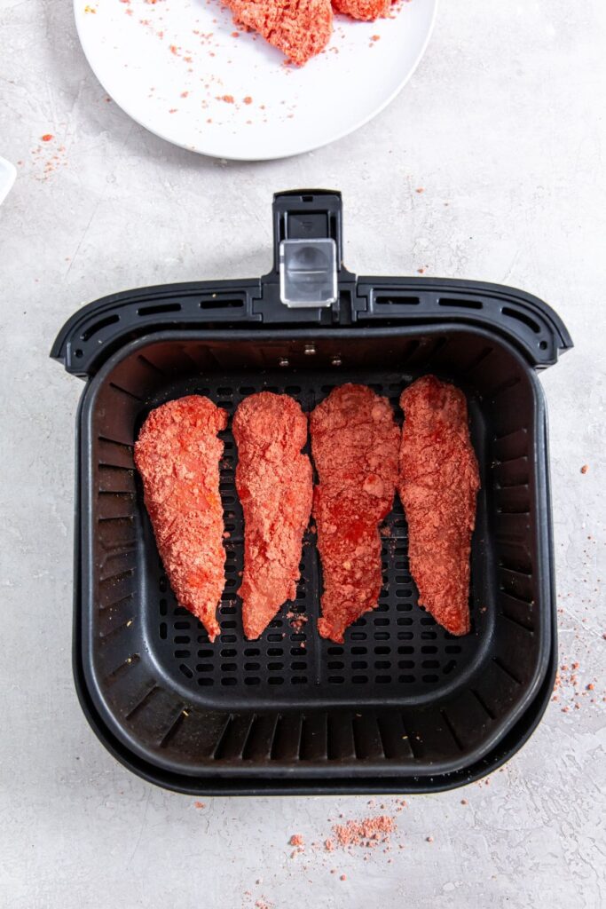 Air Fryer Flamin' Hot Cheetos Chicken Tenders black air fryer with raw chicken inside