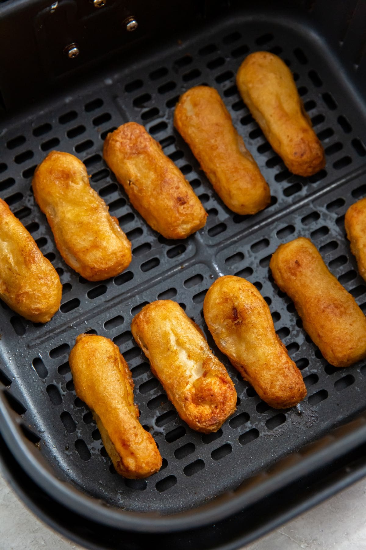 Air Fryer Tyson Honey Battered Breast Tenders black air fryer basket with cooked chicken inside