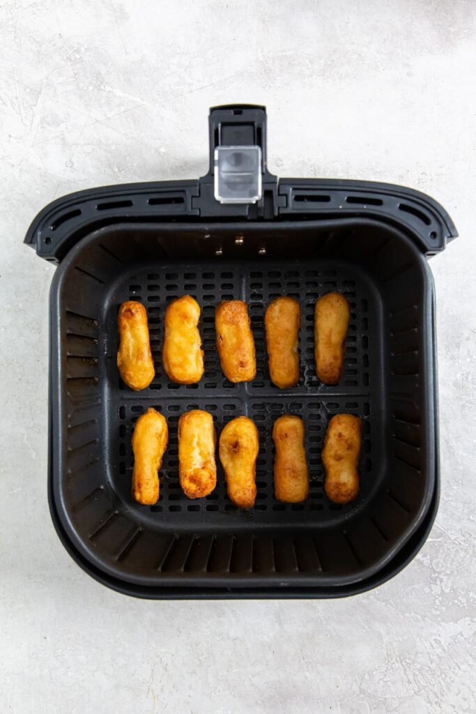 Air Fryer Tyson Honey Battered Breast Tenders black air fryer basket with cooked chicken inside