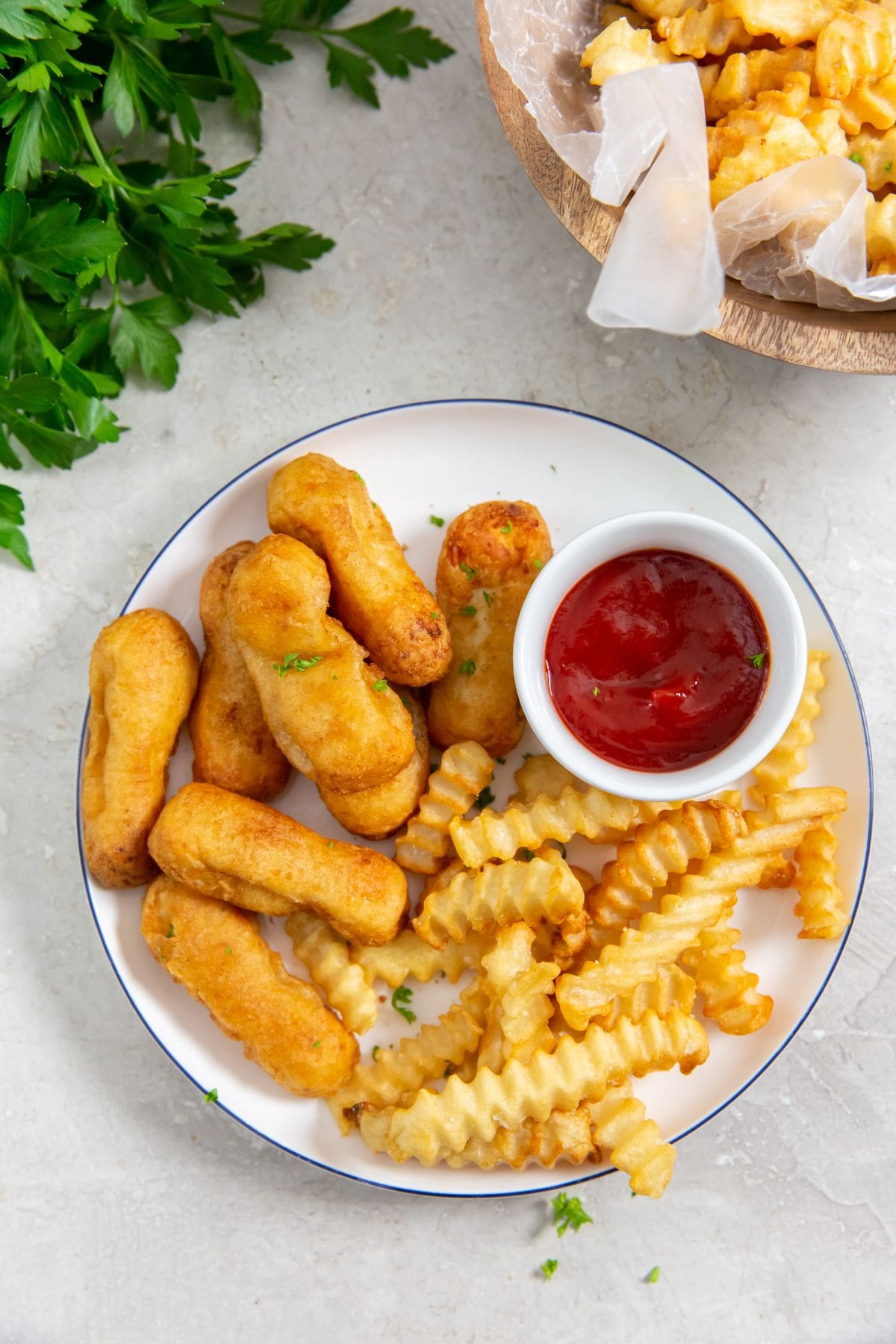 Air Fryer Tyson Honey Battered Breast Tenders plate with chicken and fries on it parsley in the back with a bowl of fries