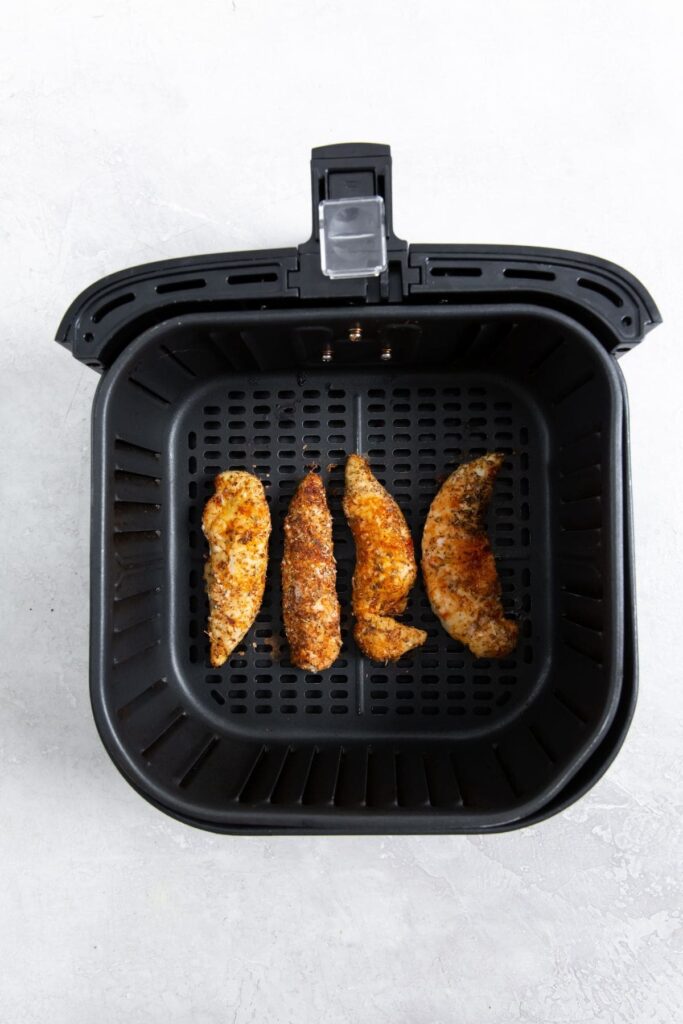 Air Fryer Blackened Chicken Tenders black air fryer with cooked chicken
