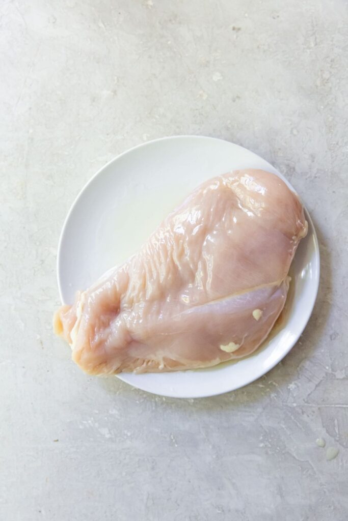 Air Fryer Blackened Chicken Breast Raw chicken breast on a white plate