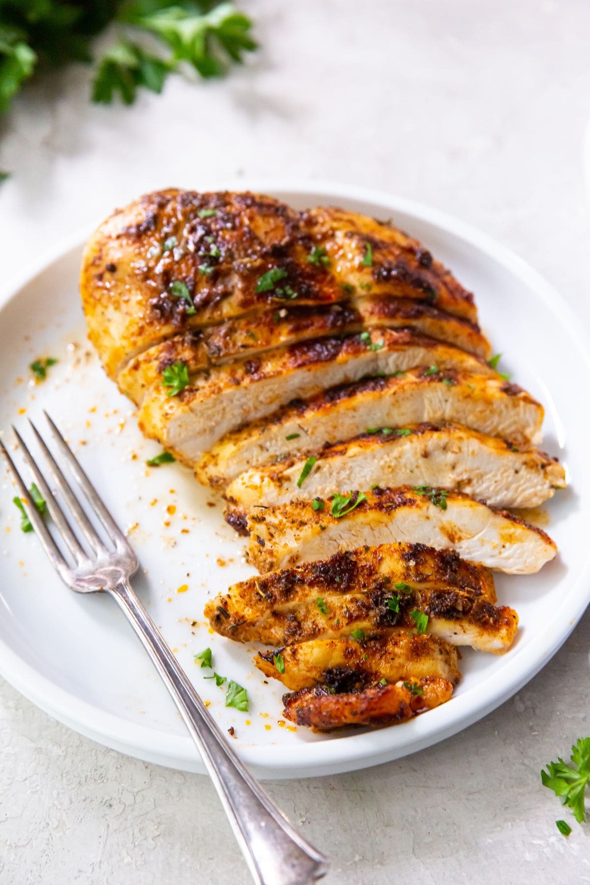 Air Fryer Blackened Chicken Breast blackened chicken breast cut up on a white plate fork on plate