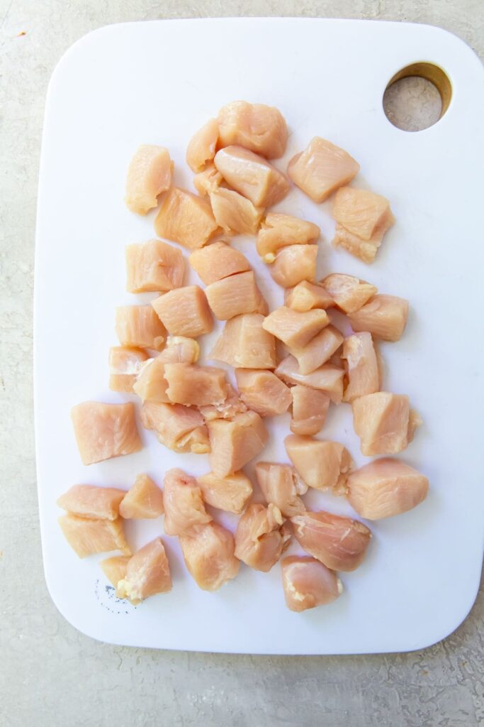Air Fryer Chicken and Veggies white cutting board with cubed chicken