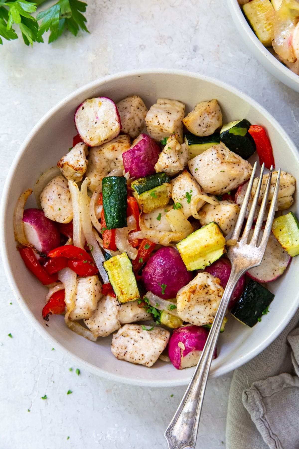 Air Fryer Chicken and Veggies White bowl with chicken and veggies inside it. Fork on top of bowl