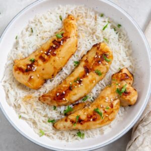 Air Fryer Teriyaki Chicken Tenders on White Rice in a White Bowl