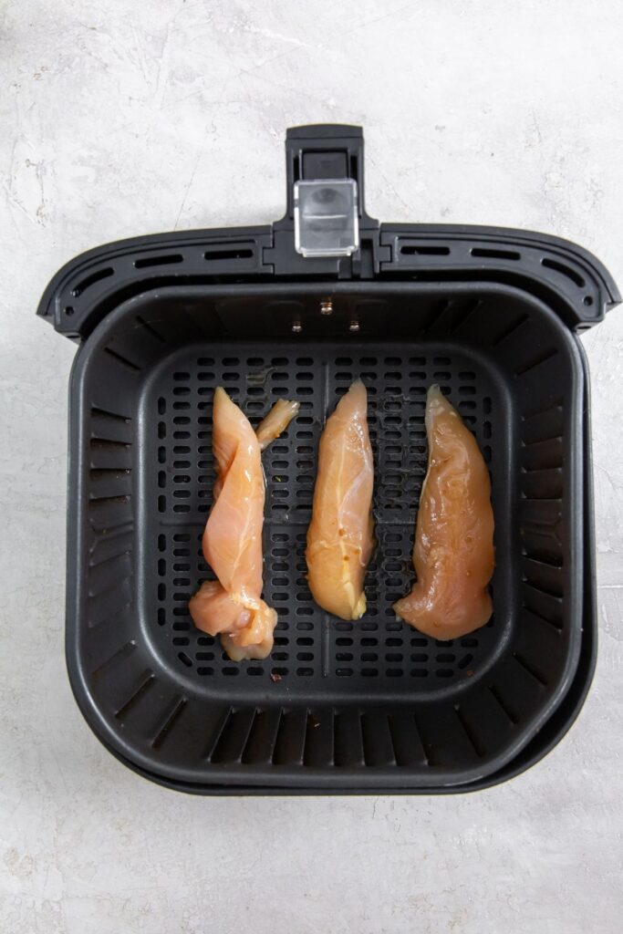 Air Fryer Teriyaki Chicken Tenders black air fryer with raw chicken inside