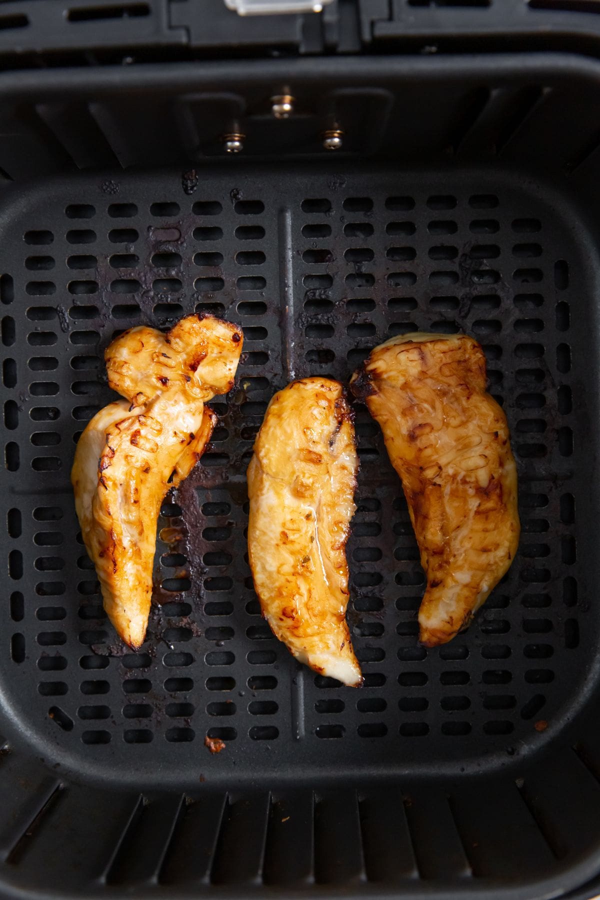 Air Fryer Teriyaki Chicken Tenders black air fryer with cooked chicken inside