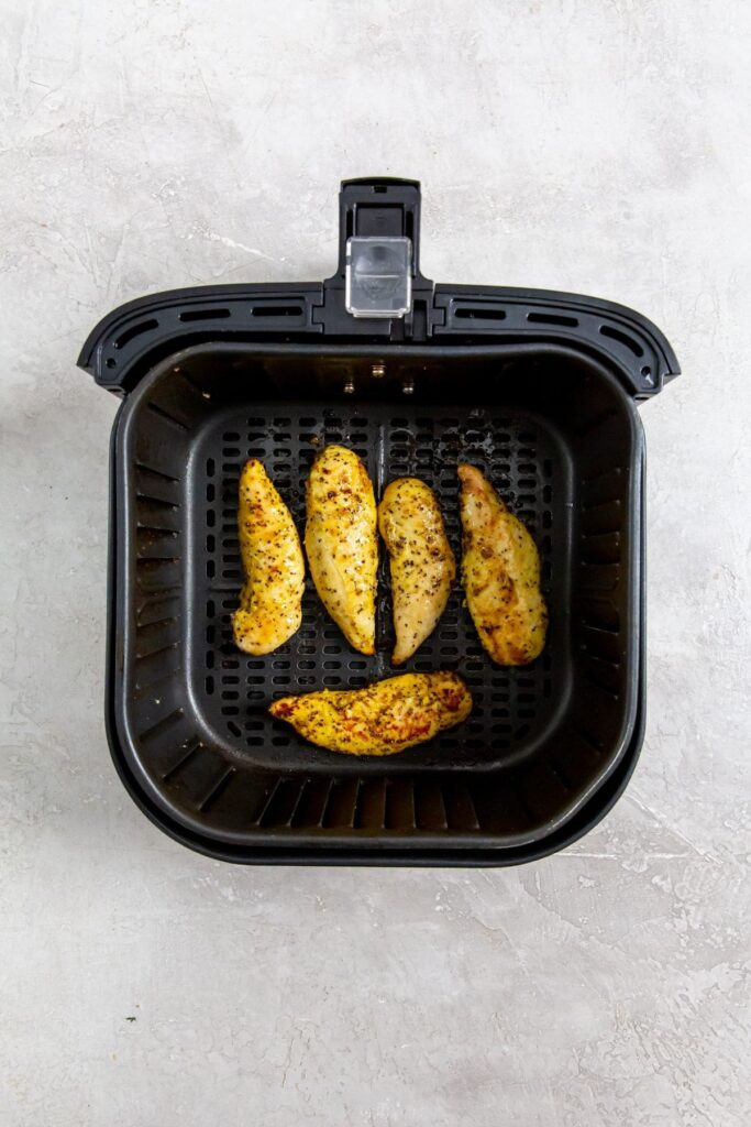 Air Fryer Lemon Pepper Chicken Tenders black air fryer basket with cooked chicken inside
