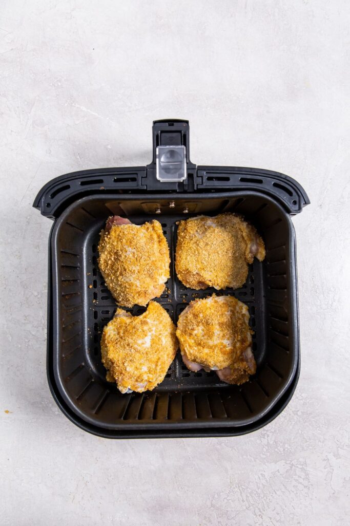 Air Fryer Shake N Bake Chicken Thighs black air fryer basket with cooked chicken inside