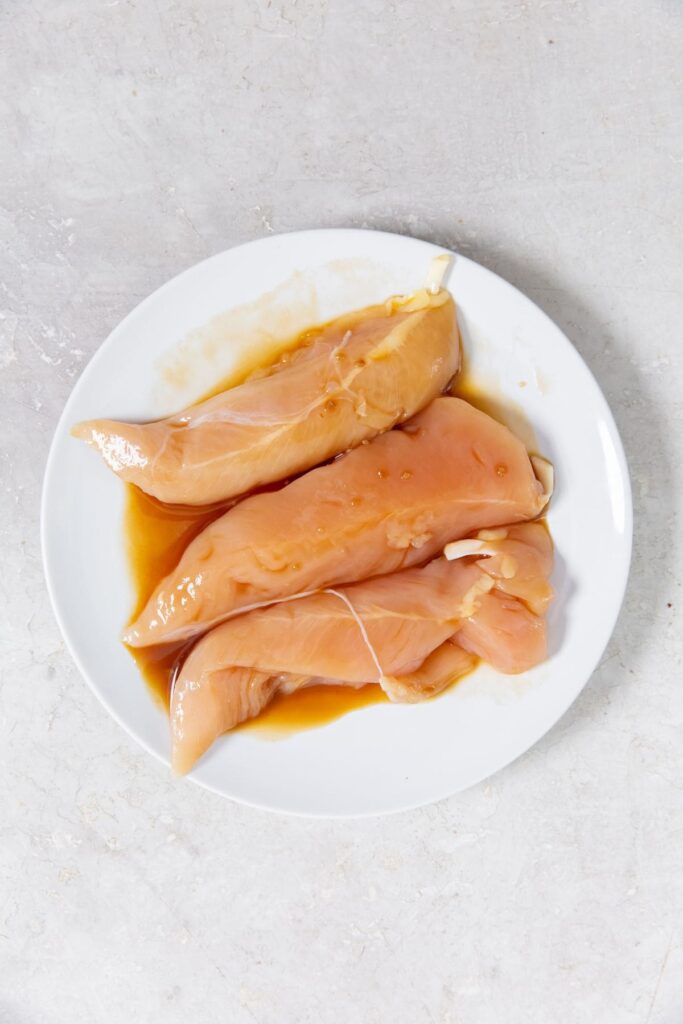 Air Fryer Teriyaki Chicken Tenders white plate with chicken and sauce on it