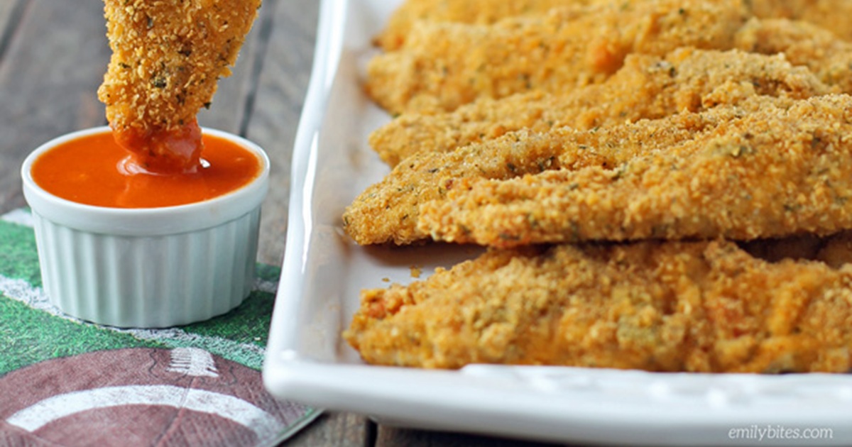Weight Watchers Air Fryer Chicken Recipes Cheddar Ranch Chicken Tenders on a Serving Platter with One Being Dipped into Buffalo Sauce
