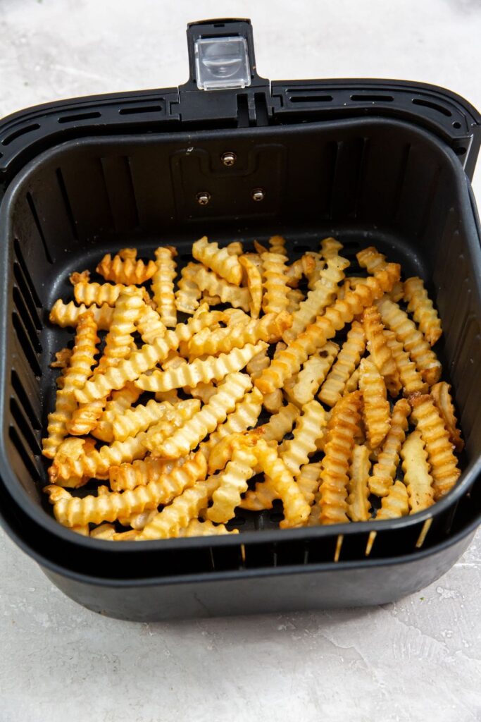 Air Fryer Crinkle Cut French Fries cooked French fries inside a air fryer basket.