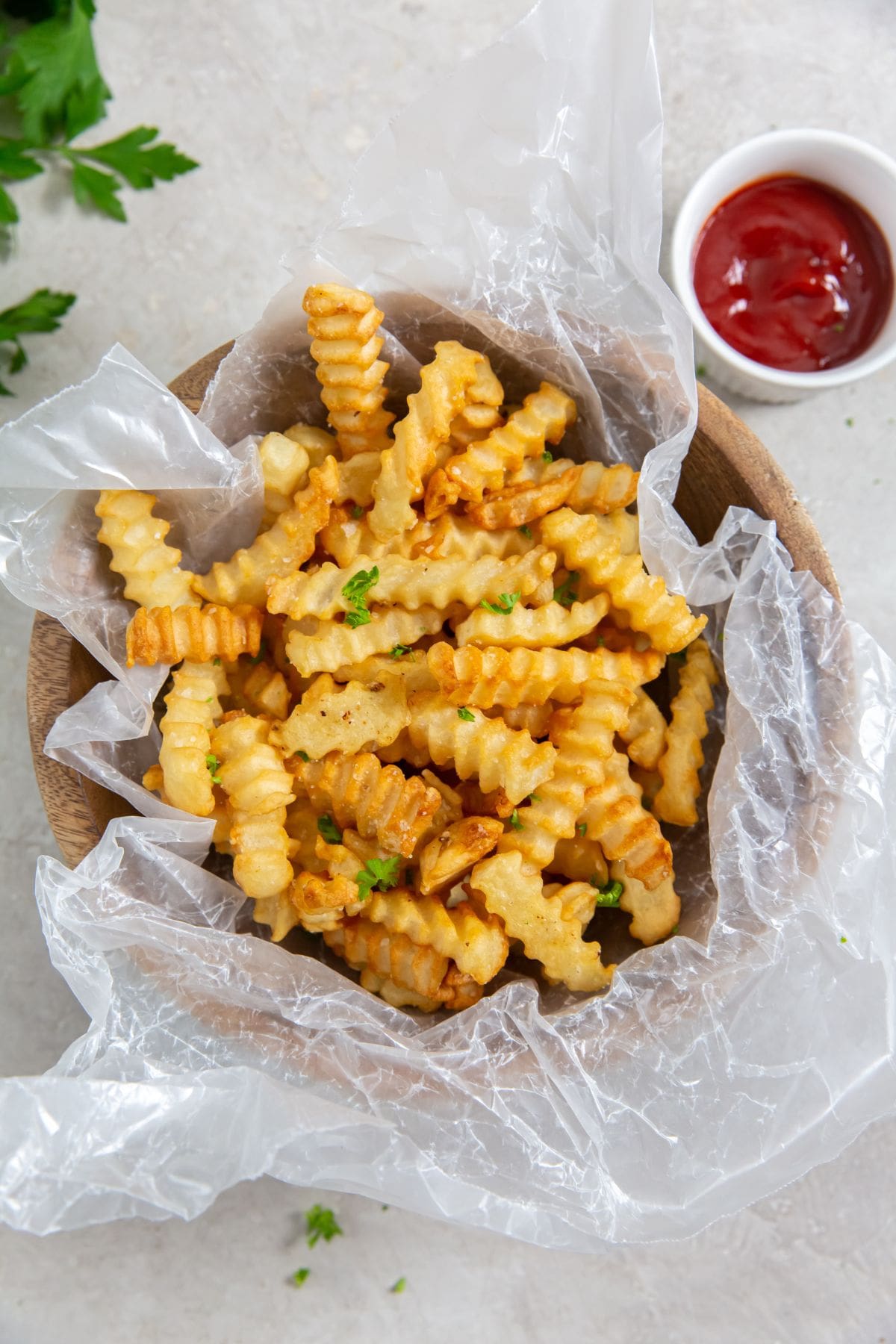 Air Fryer Crinkle Cut French Fries French fries cooked in an air fryer, served in a bowl with ketchup.
