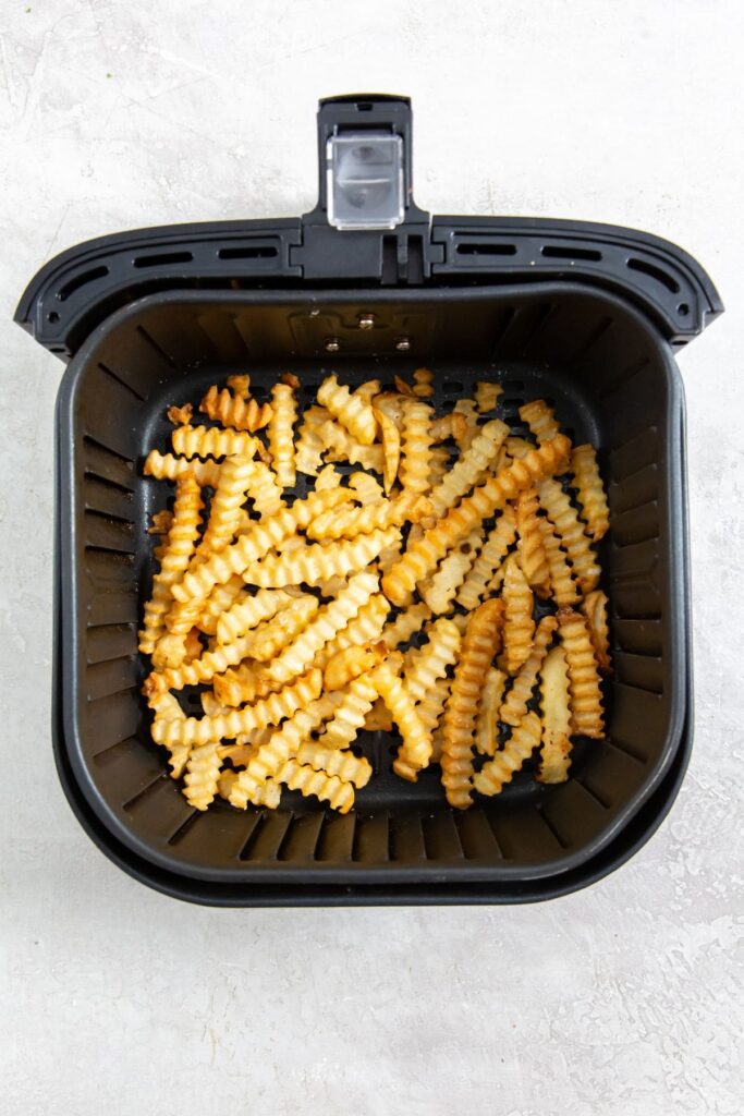Air Fryer Crinkle Cut French Fries cooked French fries inside a air fryer basket.