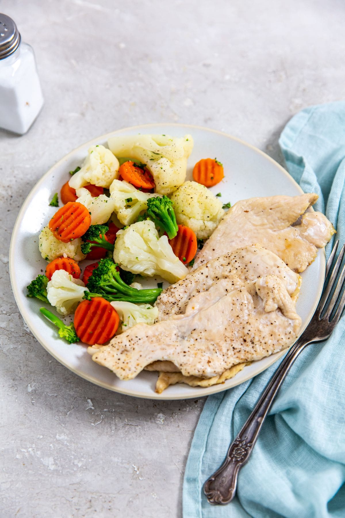 Air Fryer Thin Sliced Chicken Breast chicken breast and vegetables cooked in an air fryer, plated.
