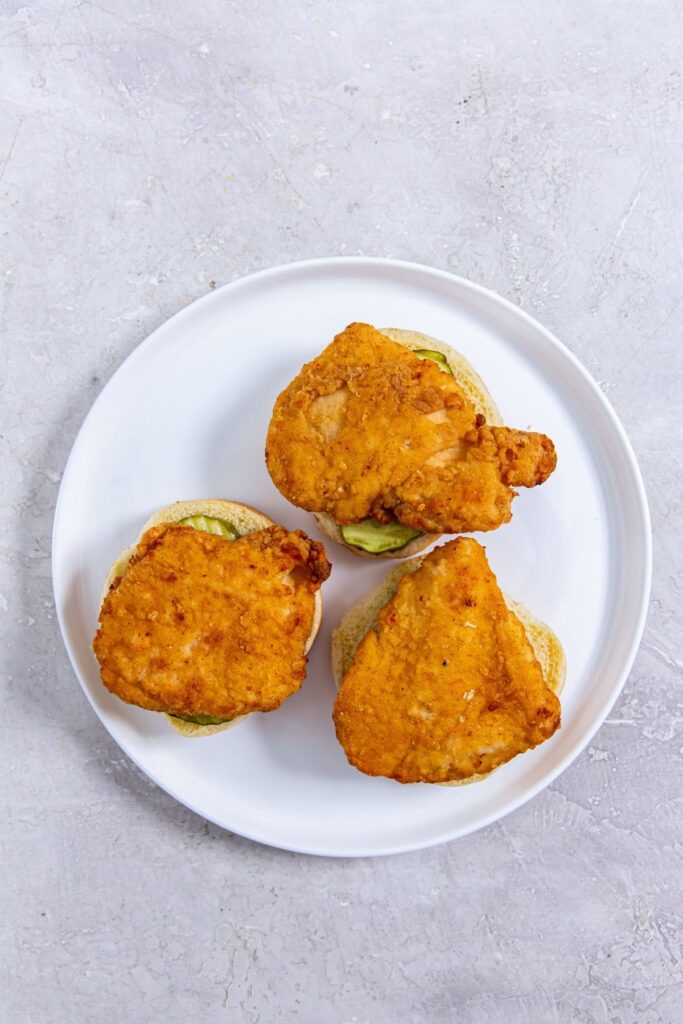 CopyCat Chick-fil-A Sandwich Three chicken sandwiches on a white plate.