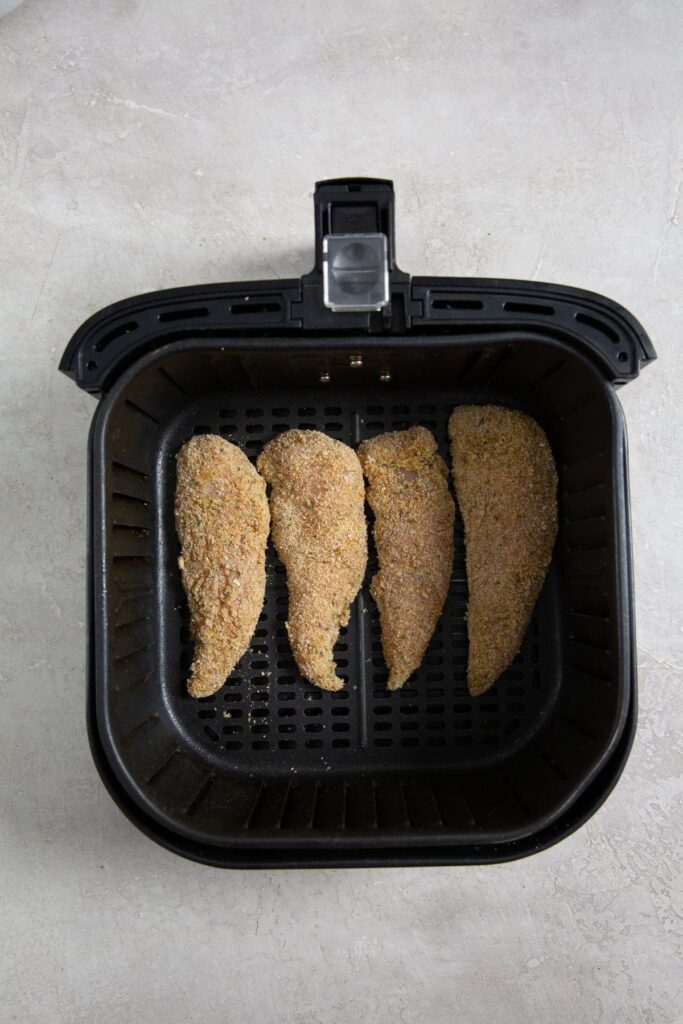 Easy Air Fryer Honey BBQ Chicken Tenders black air fryer basket with raw chicken inside