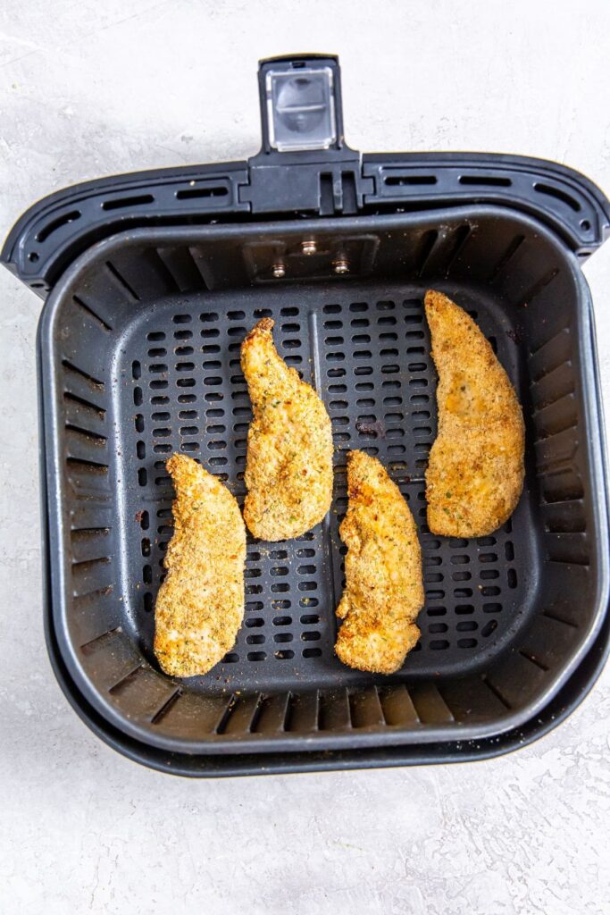 Easy Air Fryer Honey BBQ Chicken Tenders black air fryer basket with cooked chicken inside