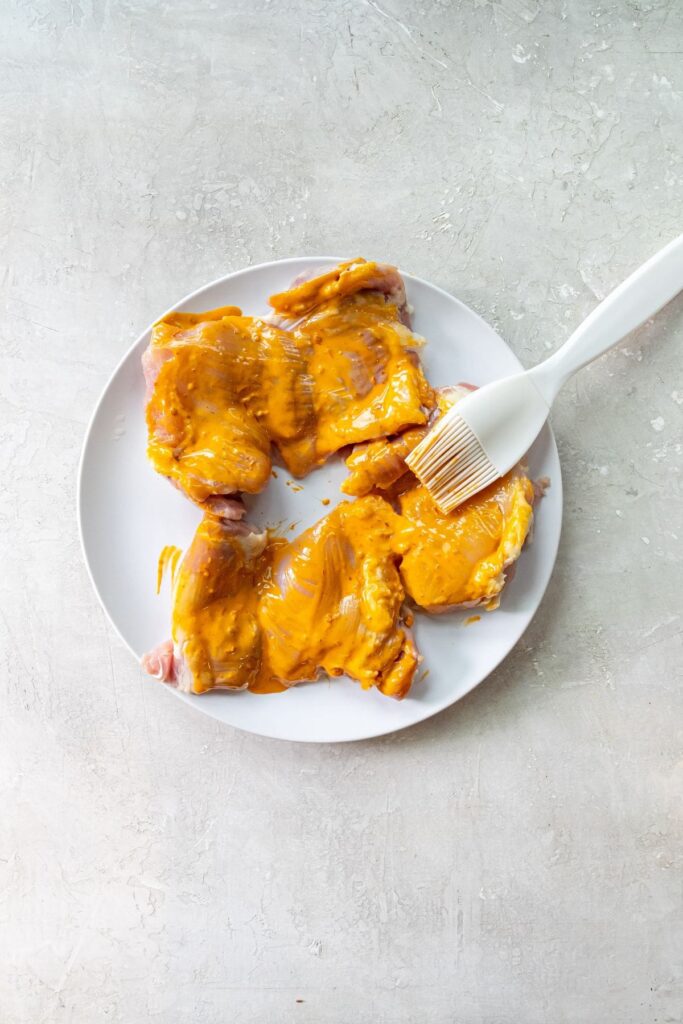 Air Fryer Peri Peri Chicken white plate with peri peri sauce brushed on the chicken