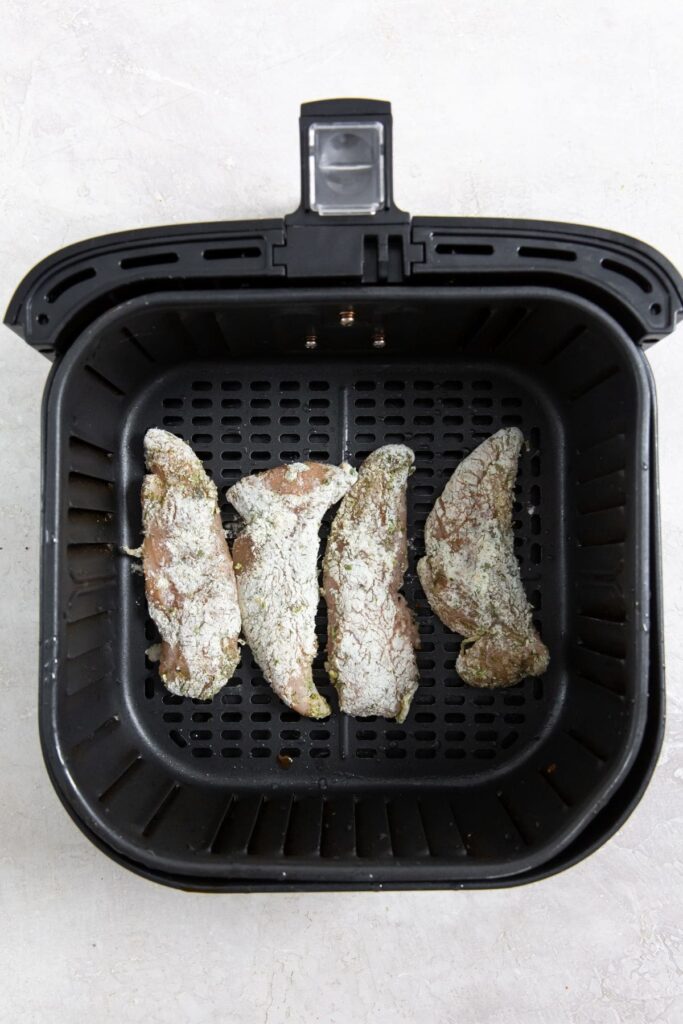 Air Fryer Ranch Chicken Tenders raw chicken inside the air fryer basket