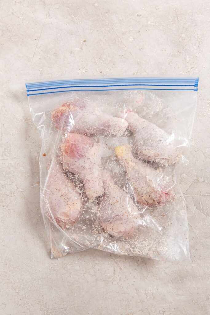 Air Fryer Crispy Chicken Legs ziplock bag with chicken coated in seasoning.