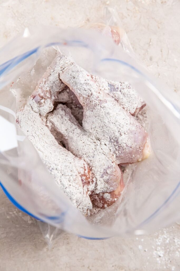 Air Fryer Crispy Chicken Legs ziplock bag with chicken coated in seasoning.